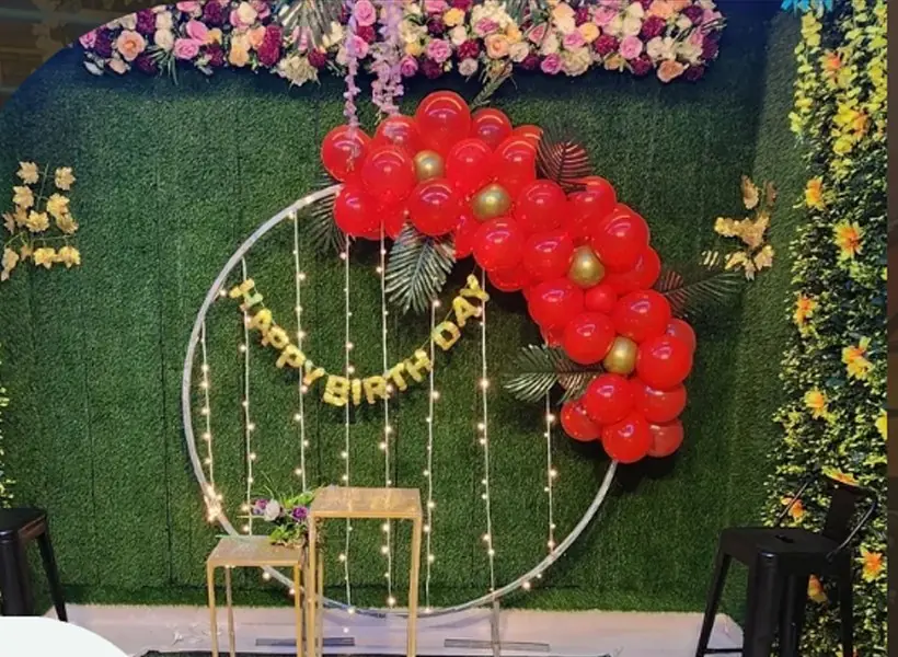 Round floral arch with red balloons and fairy lights at JD Party Box
