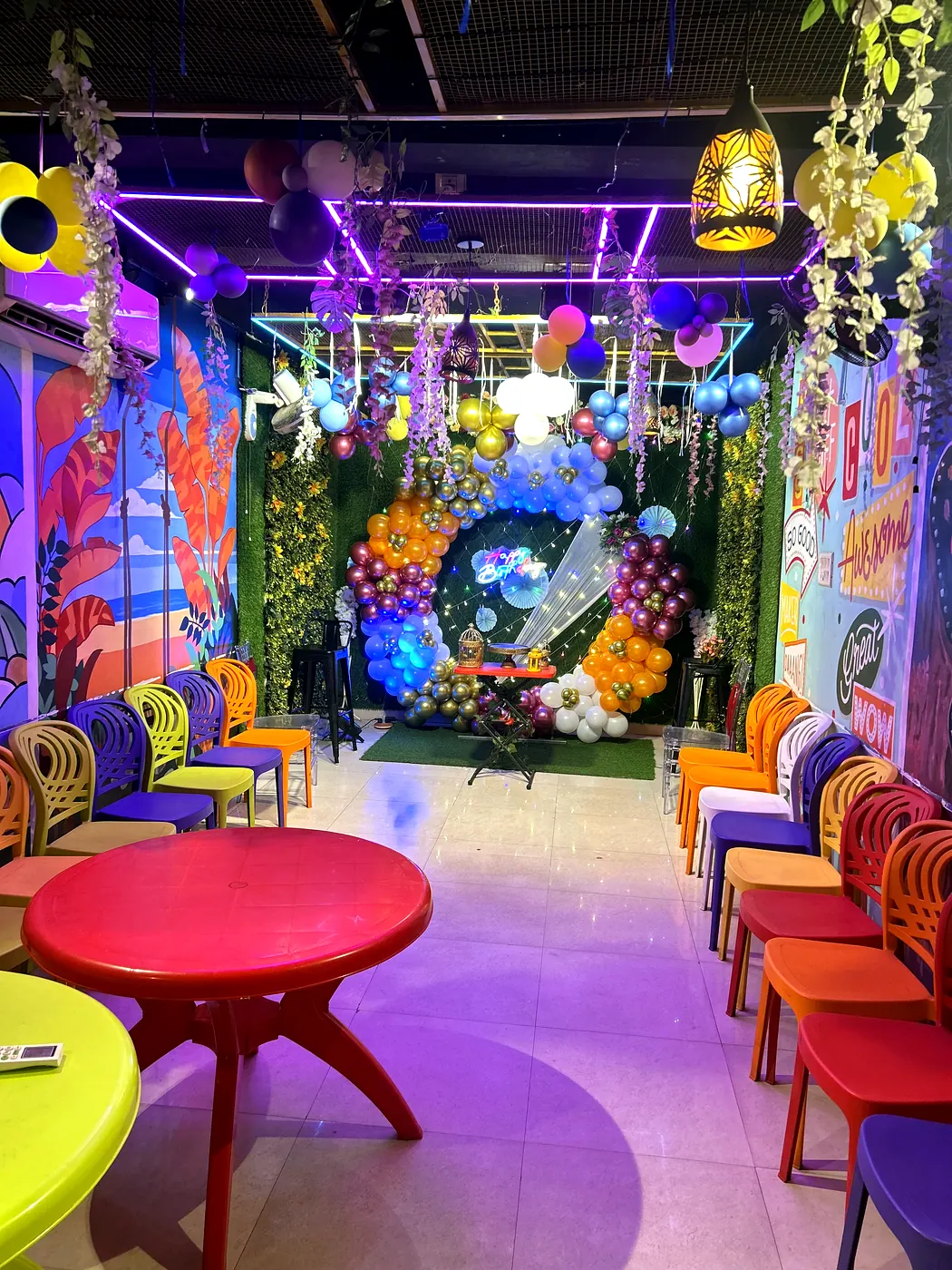 Colourful indoor hall with round balloon arch backdrop at JD Party Box