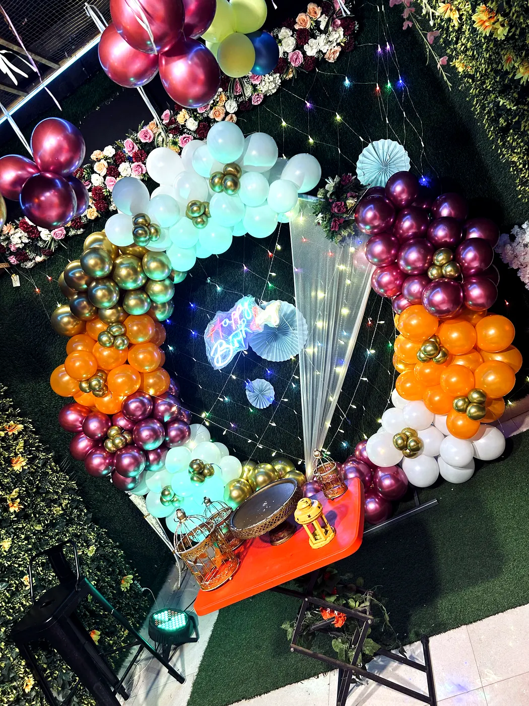 Gold orange and maroon balloon arch closeup with Happy Birthday neon at JD Party Box