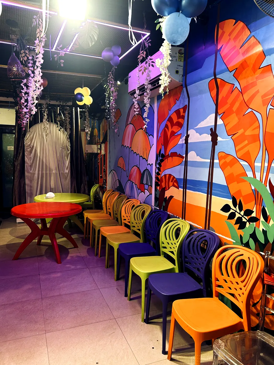 Beach themed mural with seating and tables at JD Party Box