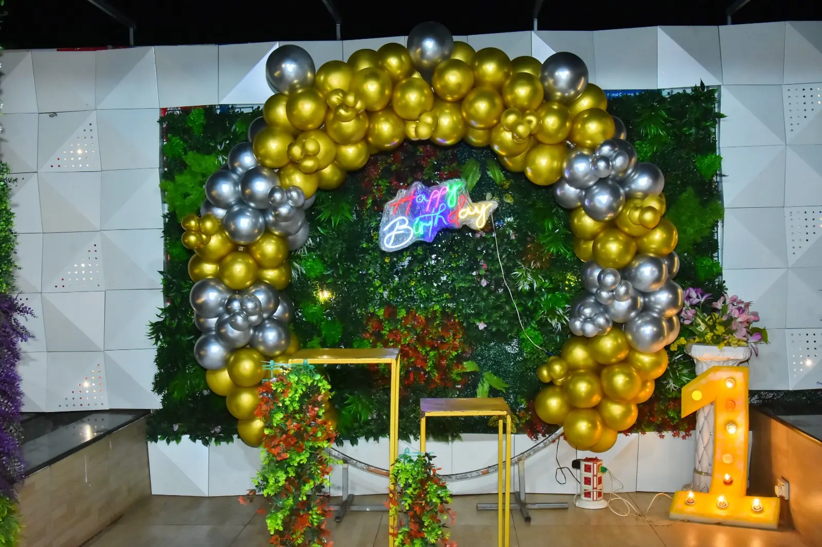 Gold and silver balloon arch with milestone birthday decor